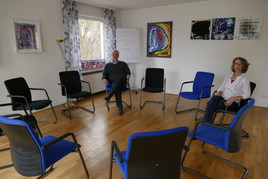 Gruppenraum mit blau-schwarzen Stühlen – König & Partner
